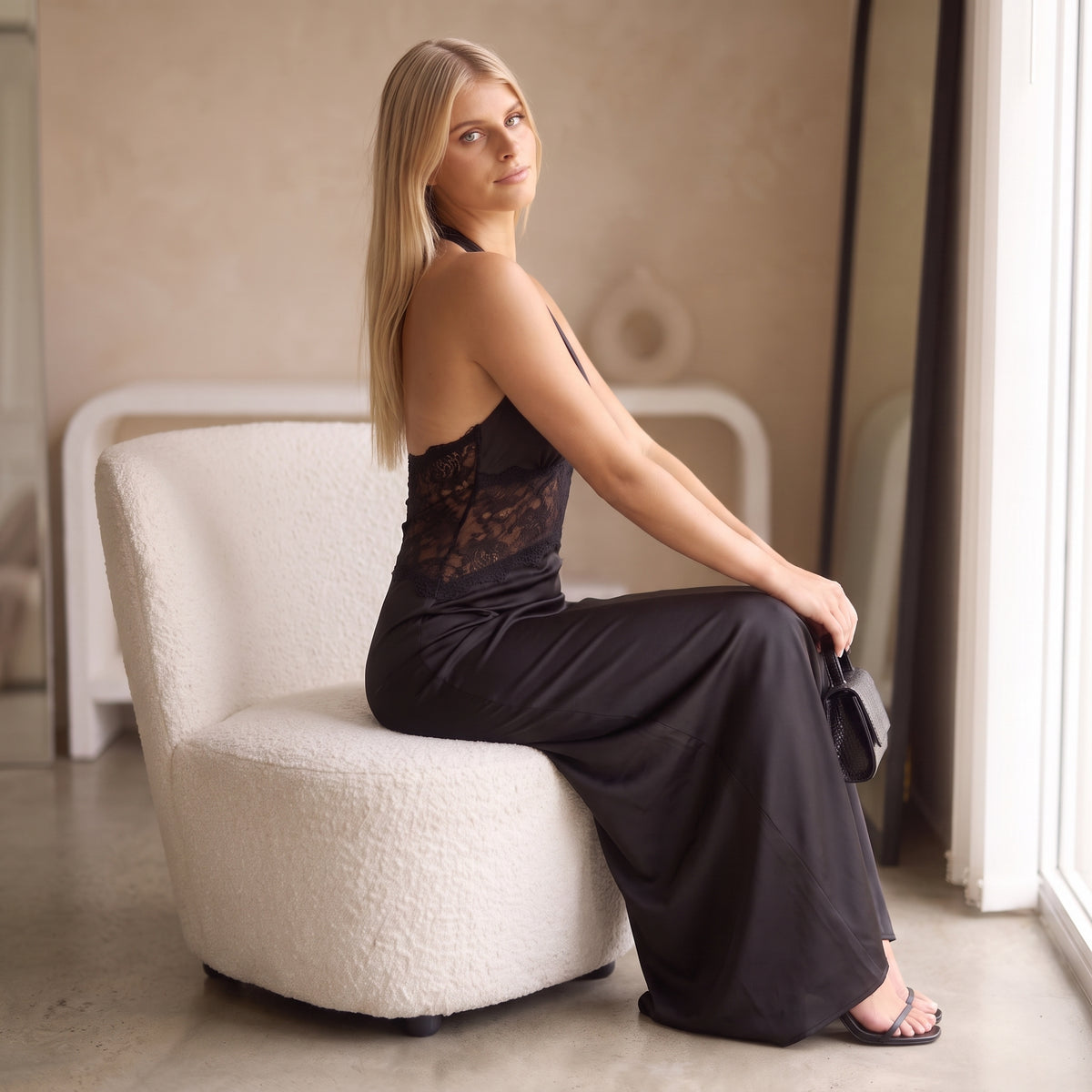 Noor black lace occasion maxi dress seated by Riley Belle